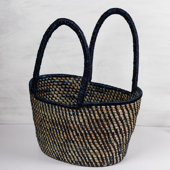 Traditional handwoven picnic basket made from sustainable materials. The basket has an intricate weaving pattern. The basket has sturdy handles for easy transport and is perfect for outdoor picnics, beach trips, or as a stylish storage solution at home.