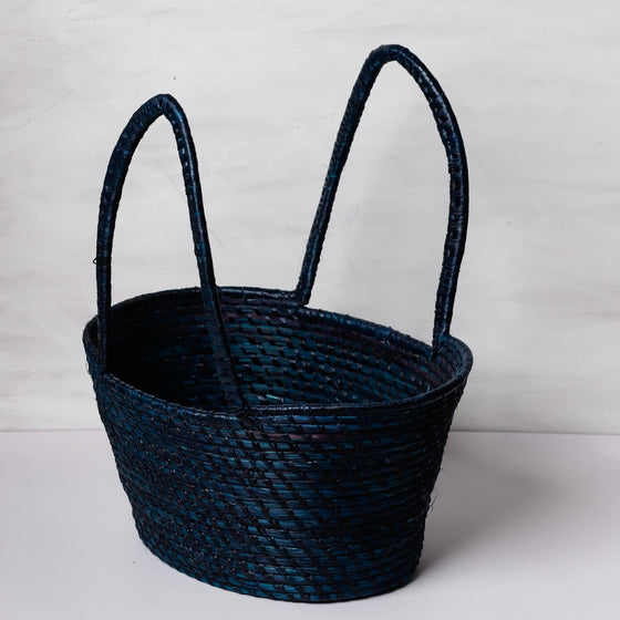 Traditional handwoven picnic basket made from sustainable materials. The basket has an intricate weaving pattern. The basket has sturdy handles for easy transport and is perfect for outdoor picnics, beach trips, or as a stylish storage solution at home.