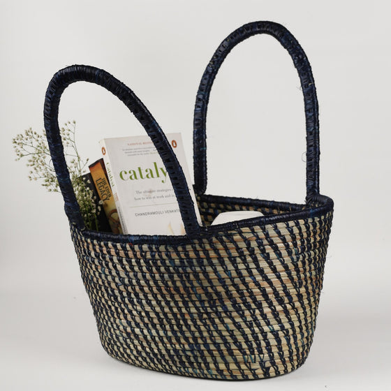 Traditional handwoven picnic basket made from sustainable materials. The basket has an intricate weaving pattern. The basket has sturdy handles for easy transport and is perfect for outdoor picnics, beach trips, or as a stylish storage solution at home.