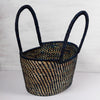 Traditional handwoven picnic basket made from sustainable materials. The basket has an intricate weaving pattern. The basket has sturdy handles for easy transport and is perfect for outdoor picnics, beach trips, or as a stylish storage solution at home.